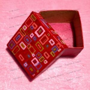 Boîte décorative acrylique aux motifs géométriques sur fond rouge par Suzana Dessalien, 5x5x3cm