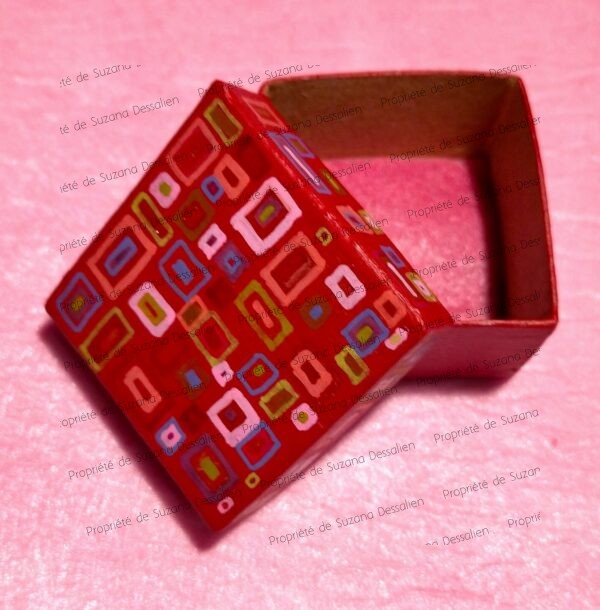 Boîte décorative acrylique aux motifs géométriques sur fond rouge par Suzana Dessalien, 5x5x3cm
